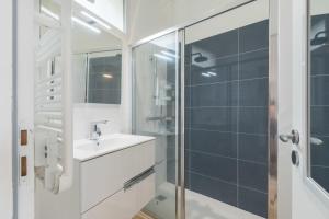 y baño con lavabo y ducha acristalada. en Maison familiale avec vue sur mer, en La Bernerie-en-Retz