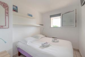 ein Schlafzimmer mit einem weißen Bett mit zwei Handtüchern darauf in der Unterkunft Appartement vue sur Golf de Pornic in Pornic