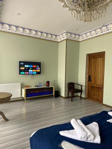 a room with a bed and a tv on the wall at Hotel Zarhal in Bukhara