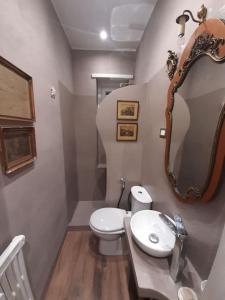 bagno con lavandino, servizi igienici e specchio di Appartamento Suite Ponte Milvio a Roma