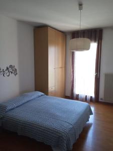 - une chambre avec un lit bleu et une fenêtre dans l'établissement Appartamento comodo al Campus licei e Faber box., à Schio