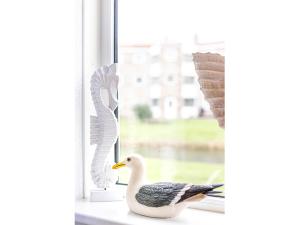 a duck sitting on a window sill next to a bird at Residence Juliana 68 in Julianadorp