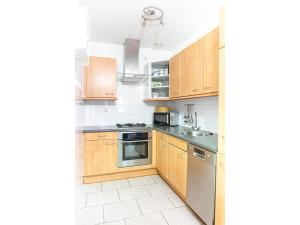 a kitchen with wooden cabinets and stainless steel appliances at Residence Juliana 68 in Julianadorp