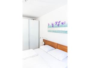a bedroom with two beds and a painting on the wall at Residence Juliana 68 in Julianadorp