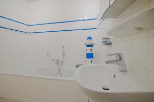 a white bathroom with a sink and a bath tub at Residence Juliana 68 in Julianadorp +5 photos