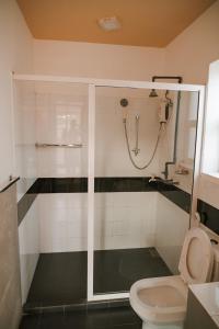 a bathroom with a shower and a toilet at Hotel Tobiko in Trincomalee