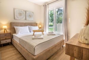 - une chambre avec un grand lit et une fenêtre dans l'établissement George Luxury Beach House, à Aiándion