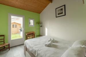een slaapkamer met een bed met twee knuffels erop bij Maison familiale avec jardin in Pornic