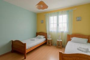 een slaapkamer met 2 bedden en een raam bij Maison familiale avec jardin in Pornic