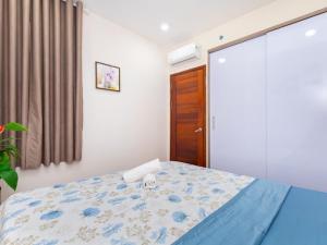 1 dormitorio con 1 cama con edredón azul en GOLD SEA Vung Tau Apartment -Tina en Vung Tau