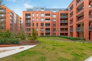 a large brick building with a lawn in front of it at Scala Apartments by Blue Mandarin in Gdańsk