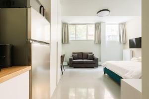 Snug studio apartment with shared garden IV في أثينا: غرفة نوم بسرير واريكة