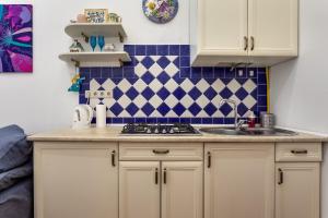 una cocina con armarios blancos y azulejos azules y blancos en ART Apartments, en Leópolis