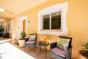 a patio with two chairs and a table and a window at Casa Kantara in Ferragudo
