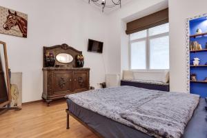 a bedroom with a bed and a dresser and a window at ART Apartments in Lviv