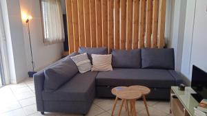 sala de estar con sofá azul y mesa en Bostani Seaside House Mani, en Agios Nikolaos