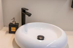 a white sink with a faucet in a bathroom at Resolana Suites in Seville