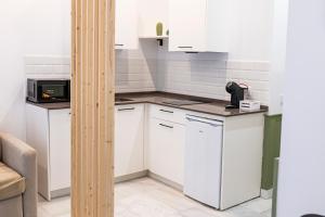 a kitchen with white cabinets and a microwave at Resolana Suites in Seville