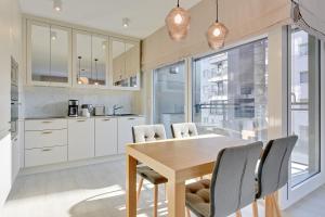 - une cuisine avec une table et des chaises en bois dans l'établissement Scala Apartments by Blue Mandarin, à Gdańsk