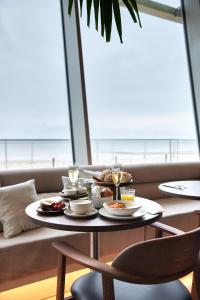 a table with plates of food on it with a view of the ocean at C-Hotels Silt in Middelkerke