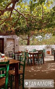 a group of wooden tables and chairs under a tree at ΠΟΛΥΞΕΝΗ -ΕΚΑΒΗ in Kondiás