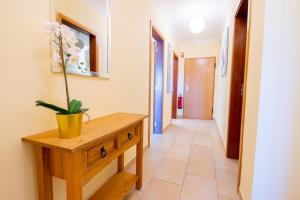 a hallway with a table and a potted plant on it at Casa Kantara in Ferragudo