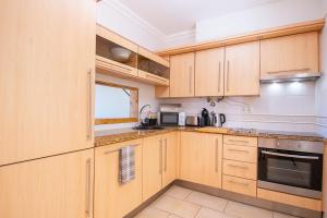 a kitchen with wooden cabinets and a stove top oven at Casa Kantara in Ferragudo +35 photos