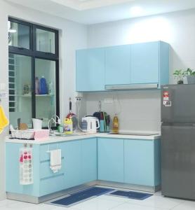a kitchen with blue cabinets and a refrigerator at 2BR2B 4-7pax 300mbps Netflix beside Paradigm mall in Johor Bahru