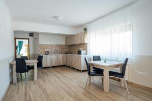a kitchen and dining room with a table and chairs at Sándor Panzió 2 in Praid