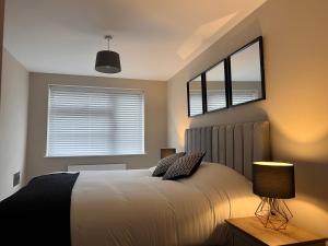 a bedroom with a bed with two pillows and a window at Cosy Suite in Shirley in Solihull