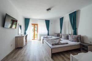 a living room with two beds and a table at Sándor Panzió 2 in Praid