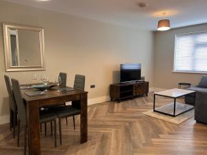 a dining room with a table with chairs and a television at Cosy Suite in Shirley in Solihull