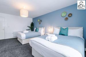 2 Betten in einem blau-weißen Zimmer in der Unterkunft Luxurious 1-Bedroom Apartment, Sleeps 4, Free Parking in Manchester