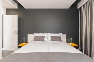 アヴェイロにあるAvenida Concept Studiosの大きな白いベッドと枕が2つある寝室