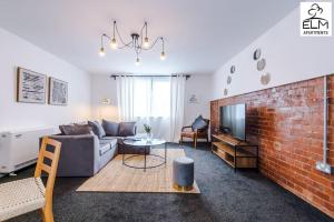 ein Wohnzimmer mit Sofa und Ziegelwand in der Unterkunft Luxurious 1-Bedroom Apartment, Sleeps 4, Free Parking in Manchester