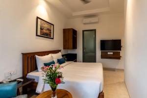 a bedroom with a bed and a vase of flowers on a table at Blessings Inn in Amritsar