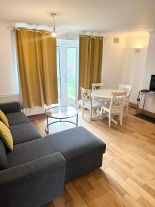 a living room with a couch and a table at Beautiful 2 bedroom garden flat w/ free parking in Surbiton