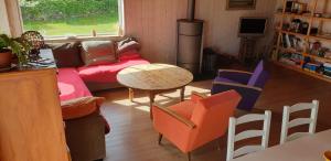 een woonkamer met een bank en een tafel en stoelen bij LE PETIT COIN DE PARADIS in Roscanvel
