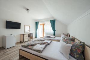 a hotel room with two beds and a television at Sándor Panzió 2 in Praid