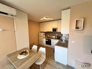 - une cuisine et une salle à manger avec une table et des chaises dans l'établissement Бийчхаус апартамент, à Bourgas