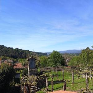 a view of a farm with a fence and trees at Pensión Rural para Peregrinos "AREAL" in Padrón