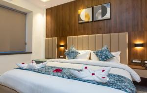 a bedroom with a large white bed with pillows at Hotel Dream Inn in Rishīkesh