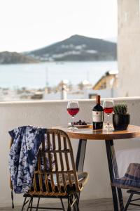 a table with two glasses of wine on a balcony at K Town Suites Naxos in Naxos Chora
