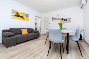 a living room with a couch and a table and chairs at Apartments Relax in Rovinj
