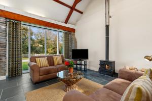a living room with couches and a fireplace at Penpedwast Upper Barn Eglwyswrw in Eglwyswrw