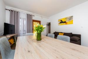 a living room with a wooden table with a vase of flowers at Apartments Relax in Rovinj