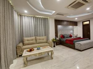 a bedroom with a bed and a couch and a table at SONESTA LUXURY APARTMENT in New Delhi