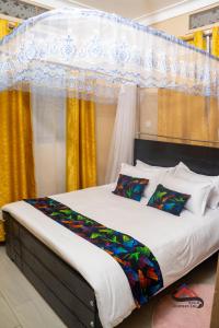 a bedroom with a large bed with yellow curtains at Kica Apartment with Airconditioned bedrooms in Lira, Uganda in Lira