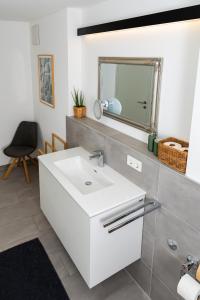 a bathroom with a white sink and a mirror at Ferienwohnung Waldrose in Waging am See