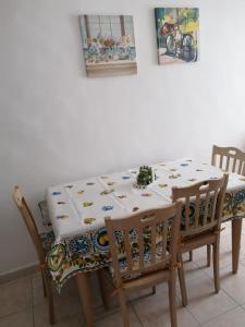 tavolo da pranzo con tovaglia e sedie bianche di Amasté in Puglia CASA VACANZA a Bisceglie